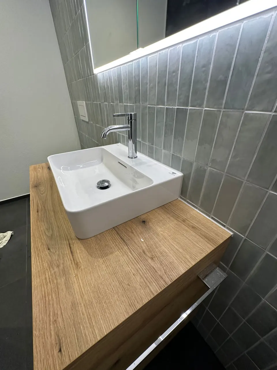 Aufsatzwaschbecken mit grünen Wandfliesen