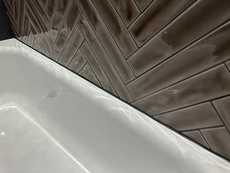 Detail der Silikonfuge zwischen Badewanne und Fliesen